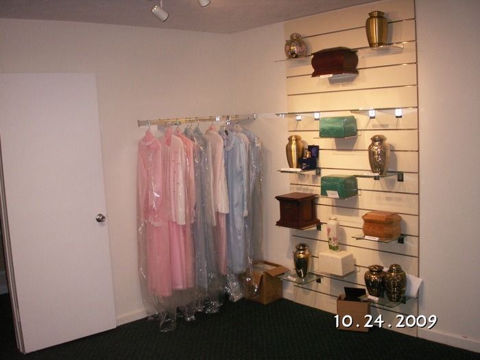Boutique interior with pastel dresses on a rack and handbags displayed on wall shelves