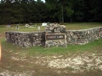 Stone memorial wall with a sign reading 