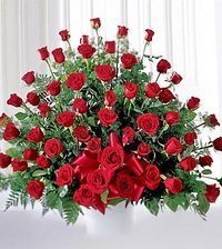 Red rose bouquet with lush green leaves in a decorative arrangement