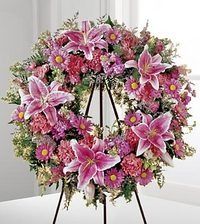 Pink and purple flower wreath on a black tripod stand