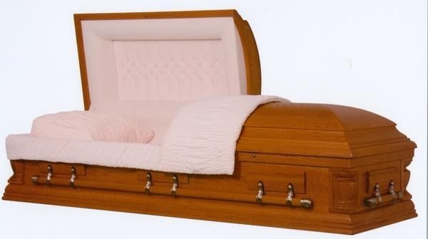 Open wooden casket with cream satin lining and pillow on a white background