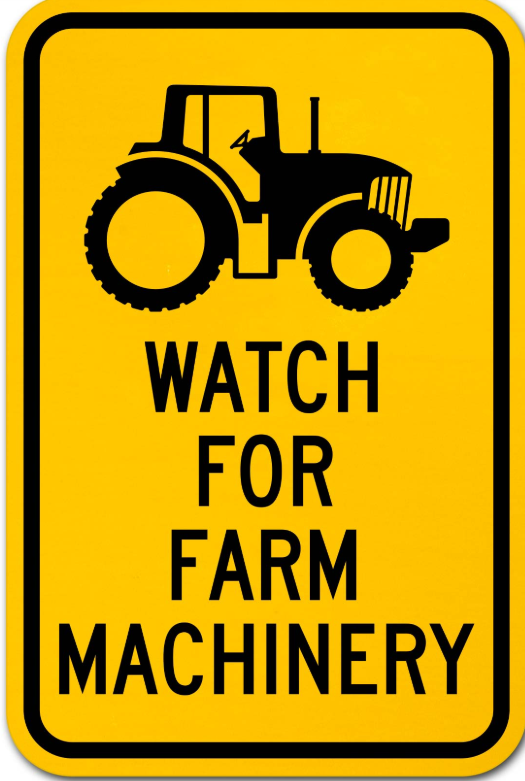 Yellow sign with black tractor icon and text: 