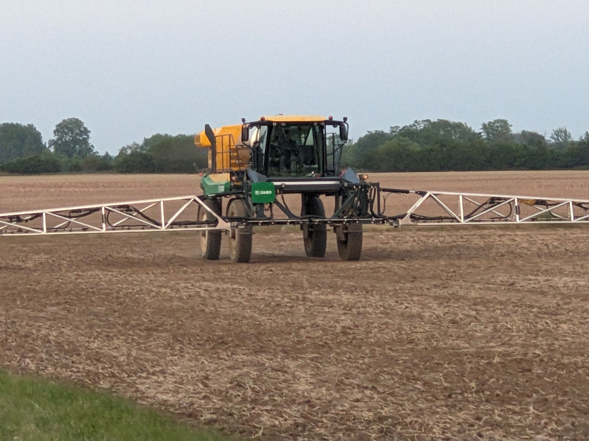 Agricultural sprayer in a field, spraying crops.
