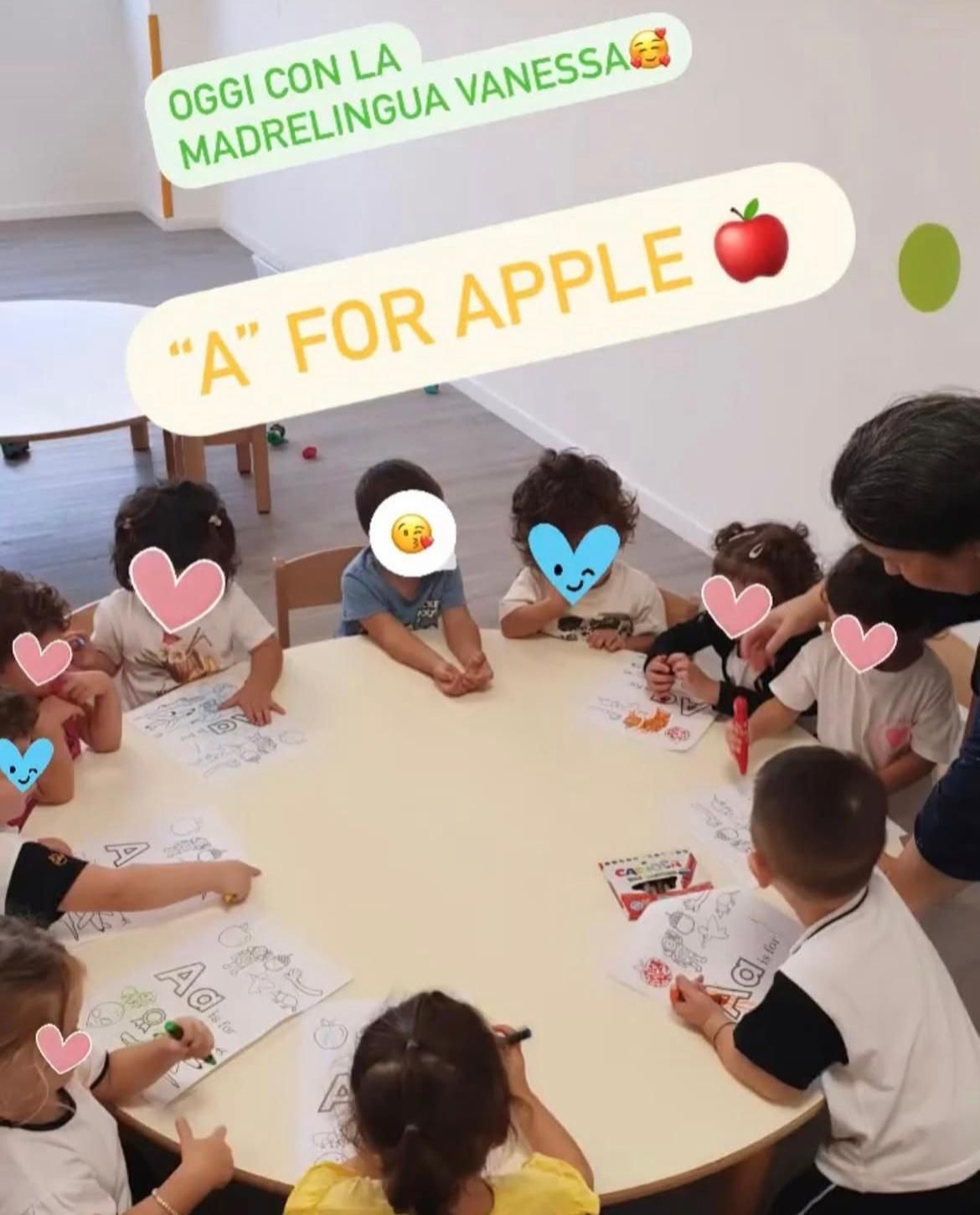 Un gruppo di bambini è seduto attorno a un tavolo con un cartello che dice 