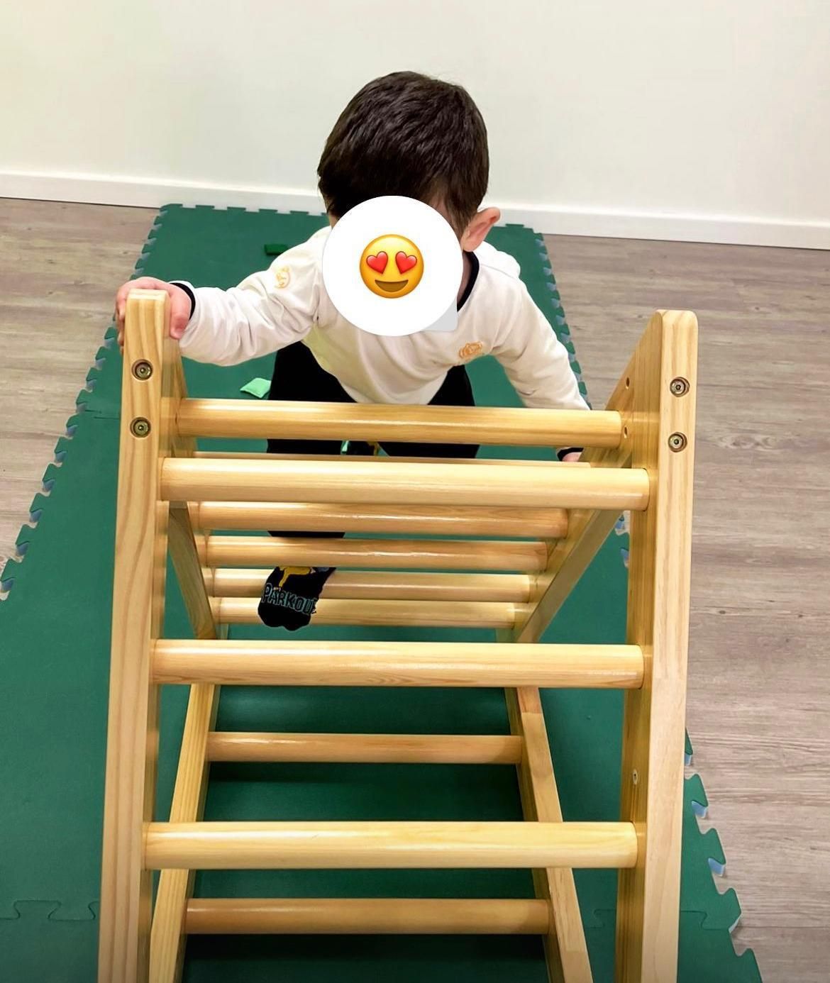Un ragazzino sta salendo una scala di legno.
