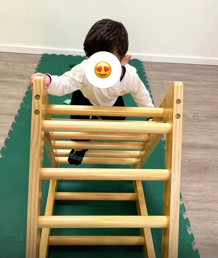 Un ragazzino sta salendo una scala di legno.