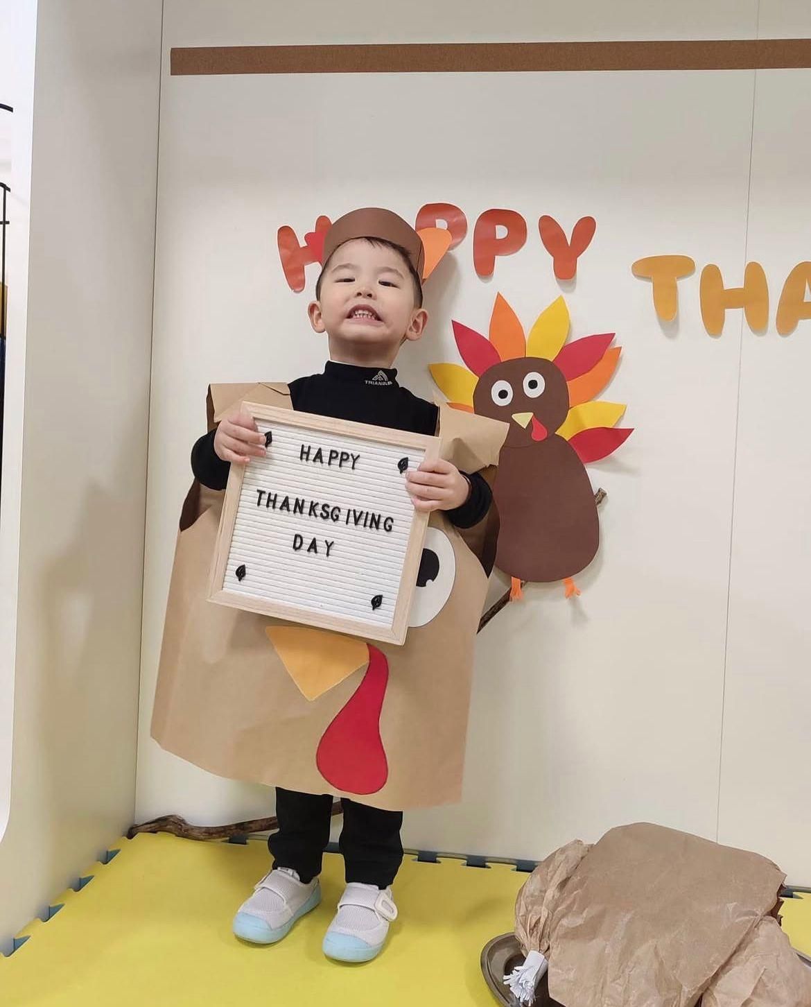Un ragazzino in costume tiene in mano un cartello con la scritta 