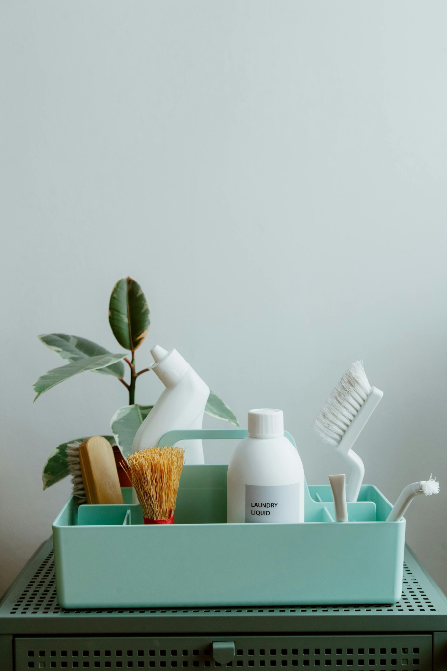 Mint bathroom caddy with toothbrushes, toothpaste, razor, and lotion on a shelf