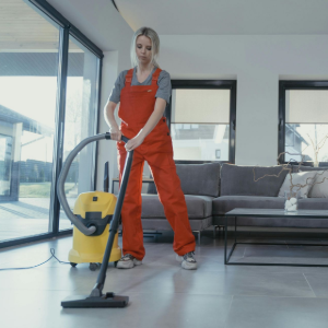 Person vacuuming a bright living room floor with a yellow vacuum cleaner