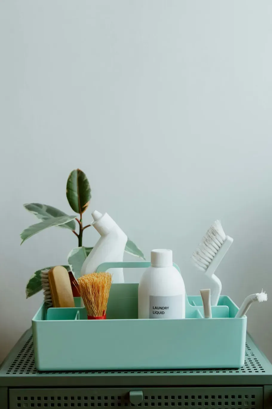 Mint bathroom caddy with toothbrushes, toothpaste, razor, and lotion on a shelf