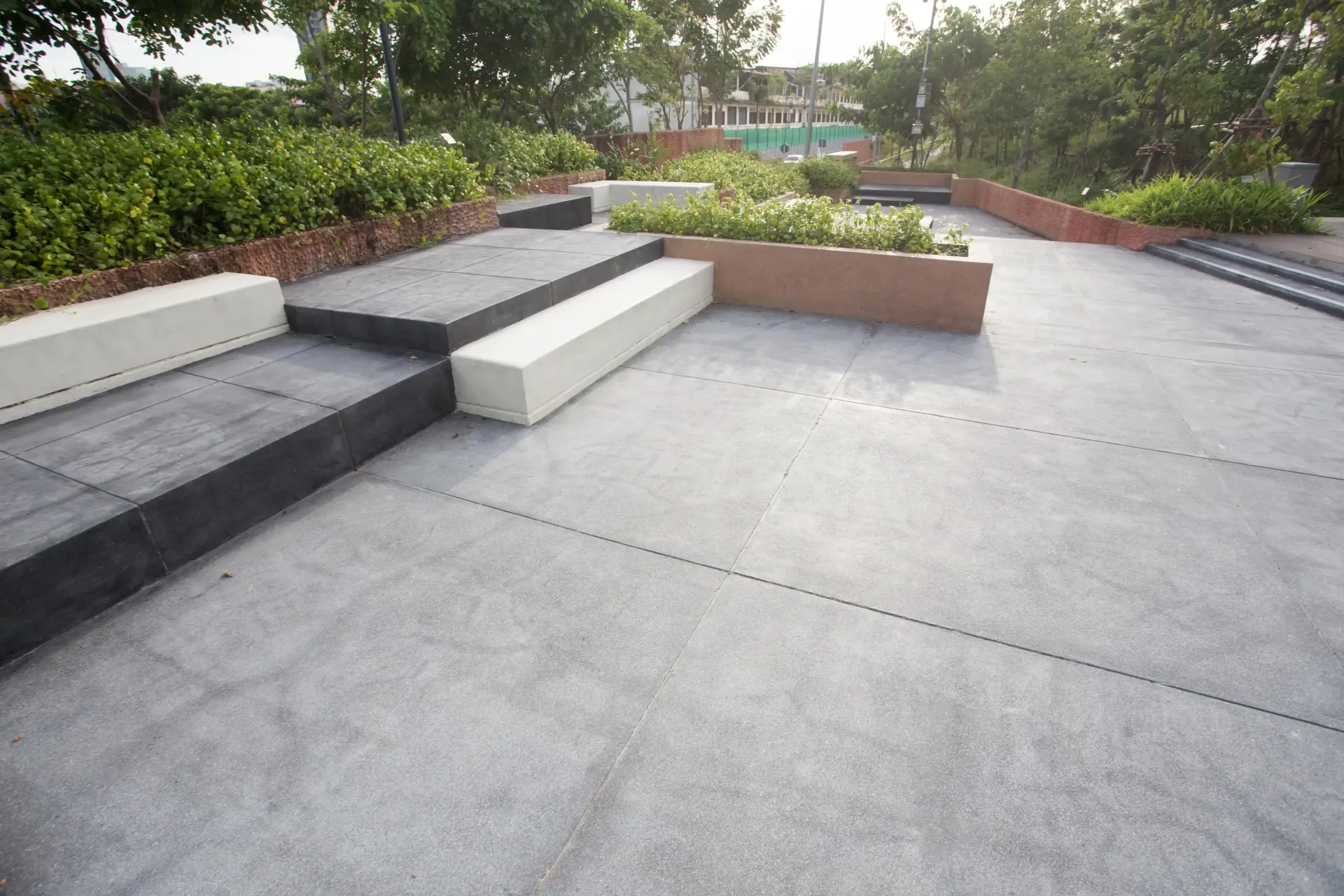 Modern patio with concrete steps, benches, and landscaped planters