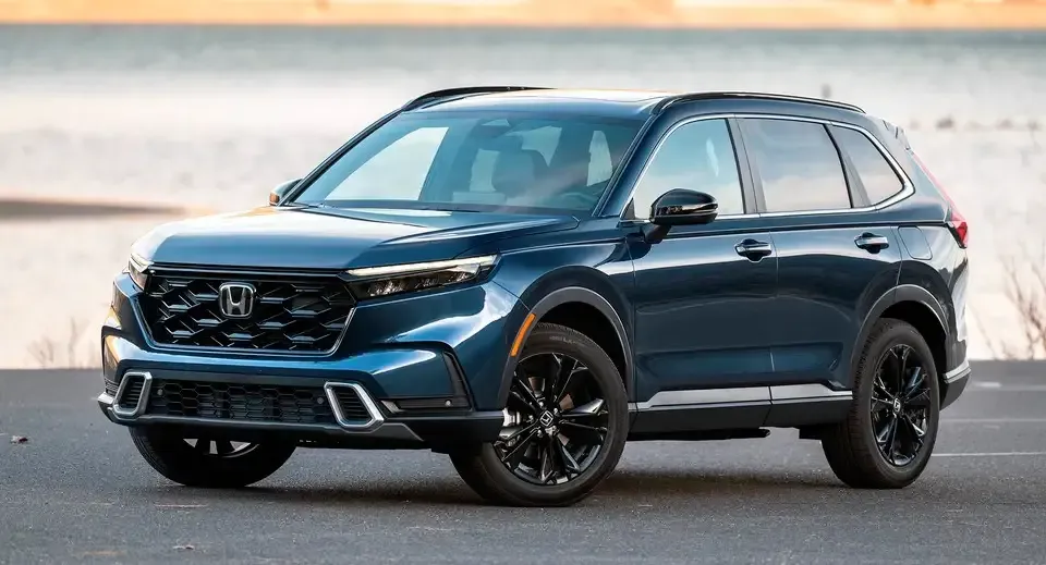 Blue Honda SUV parked on a beach road at sunset