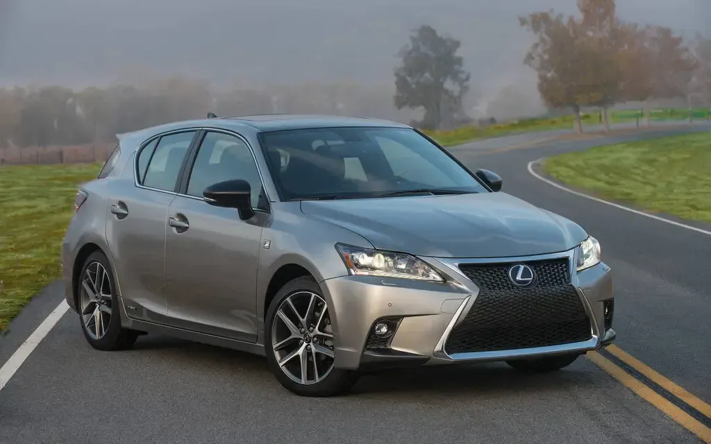 Silver Lexus sedan on a wet road in a foggy rural setting