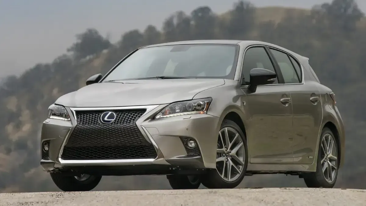 Silver Lexus sedan on a road with a blurred hillside background