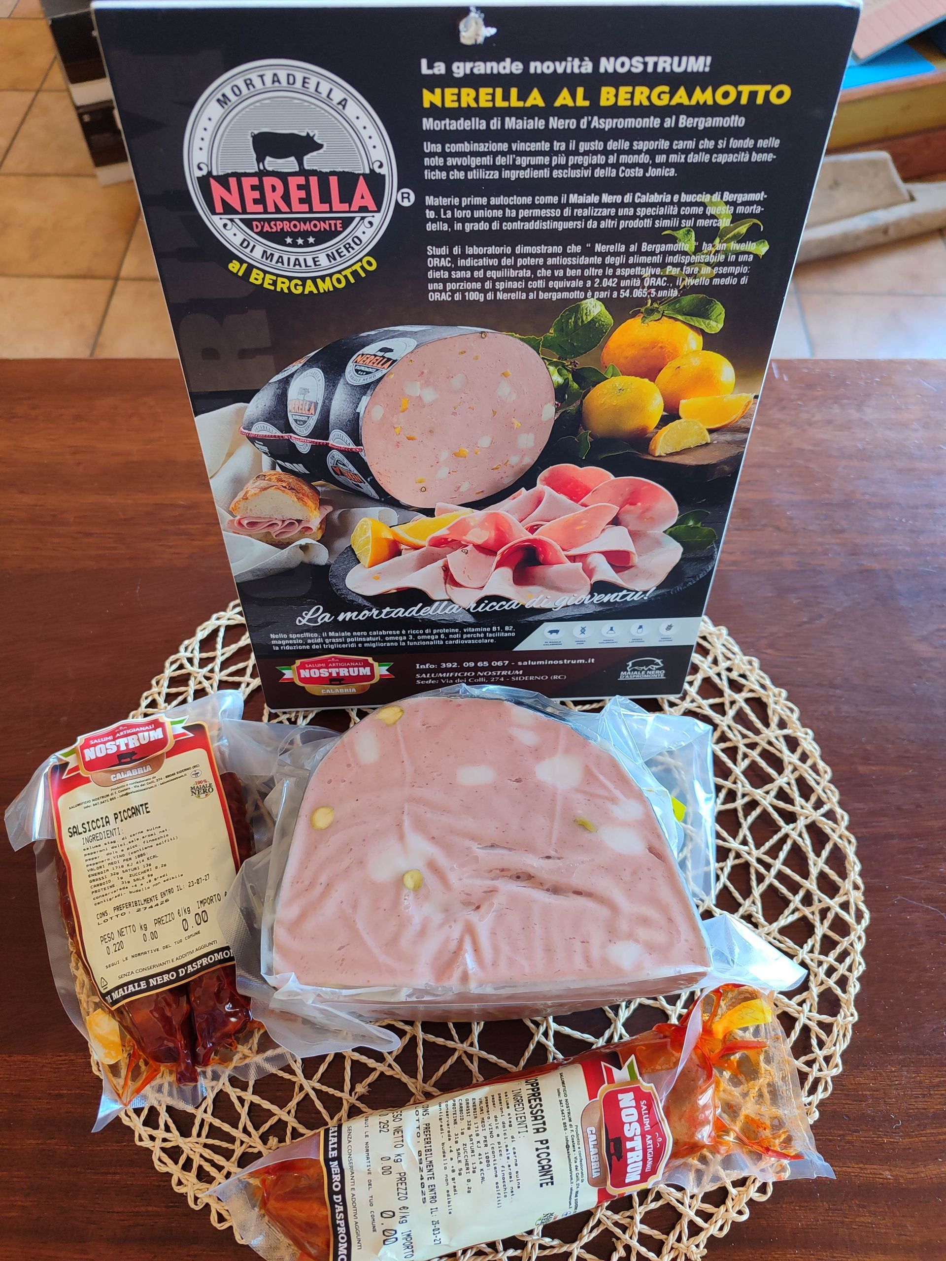 Prosciutto affettato confezionato su un vassoio intrecciato, con un’etichetta del prodotto e un cartello promozionale nero sullo sfondo