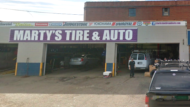 Marty’s Tire & Auto storefront with vehicles parked inside and outside the garage