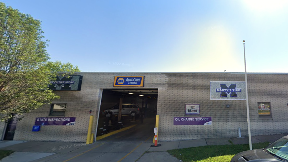 Parking garage entrance with signage, brick facade, and a blue sky overhead