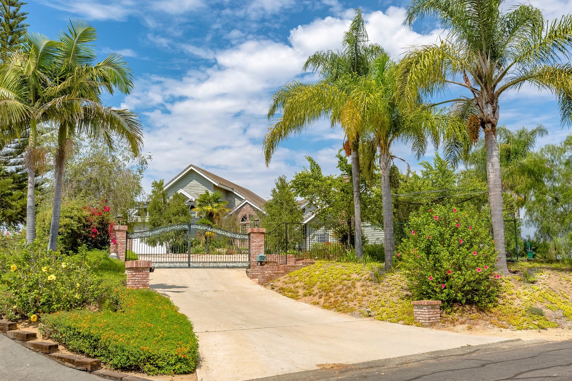 California home with gate below puffy clouds. California home with gate below puffy clouds.