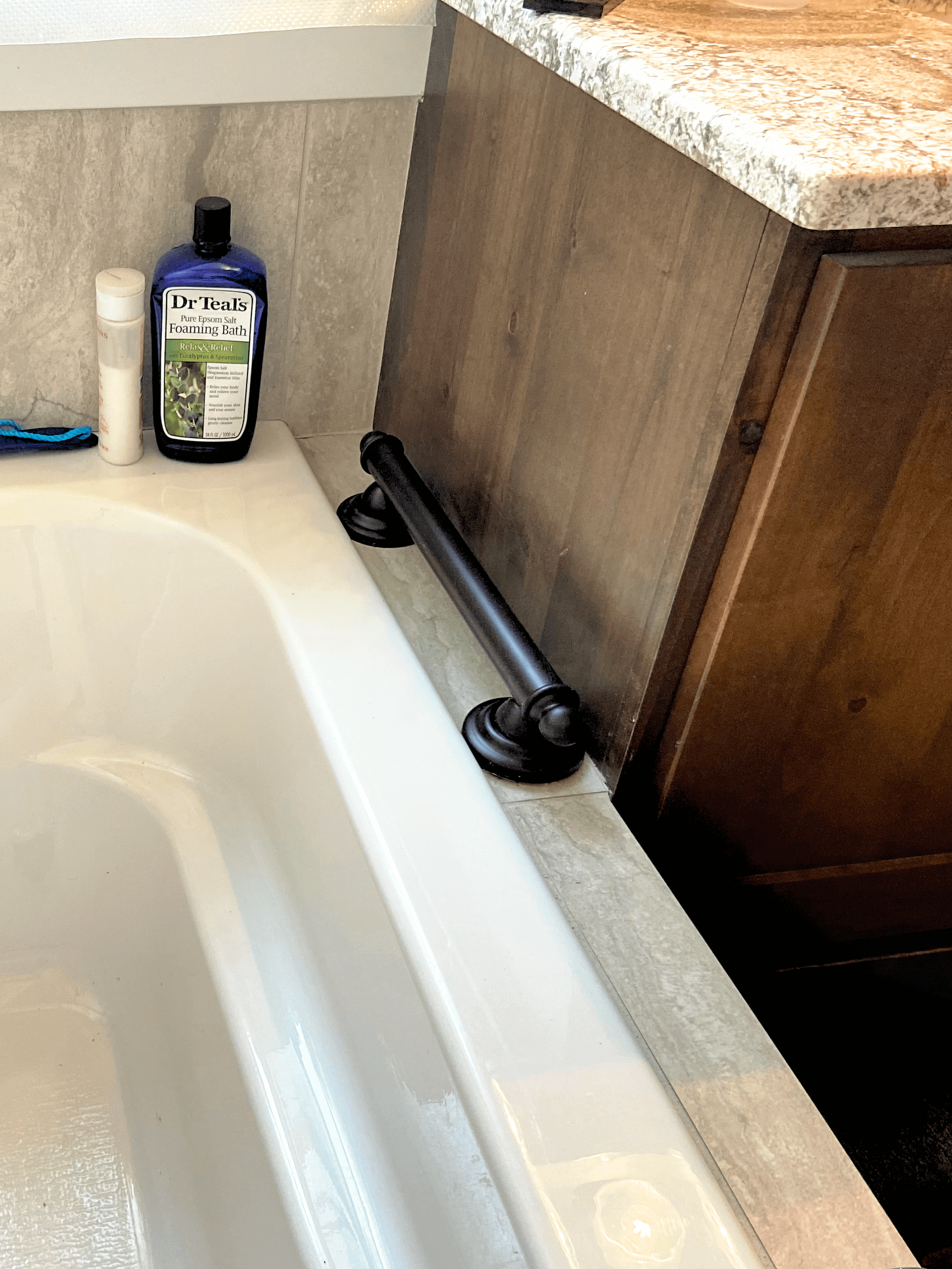A bathroom with a bathtub and a bottle of shampoo on the counter