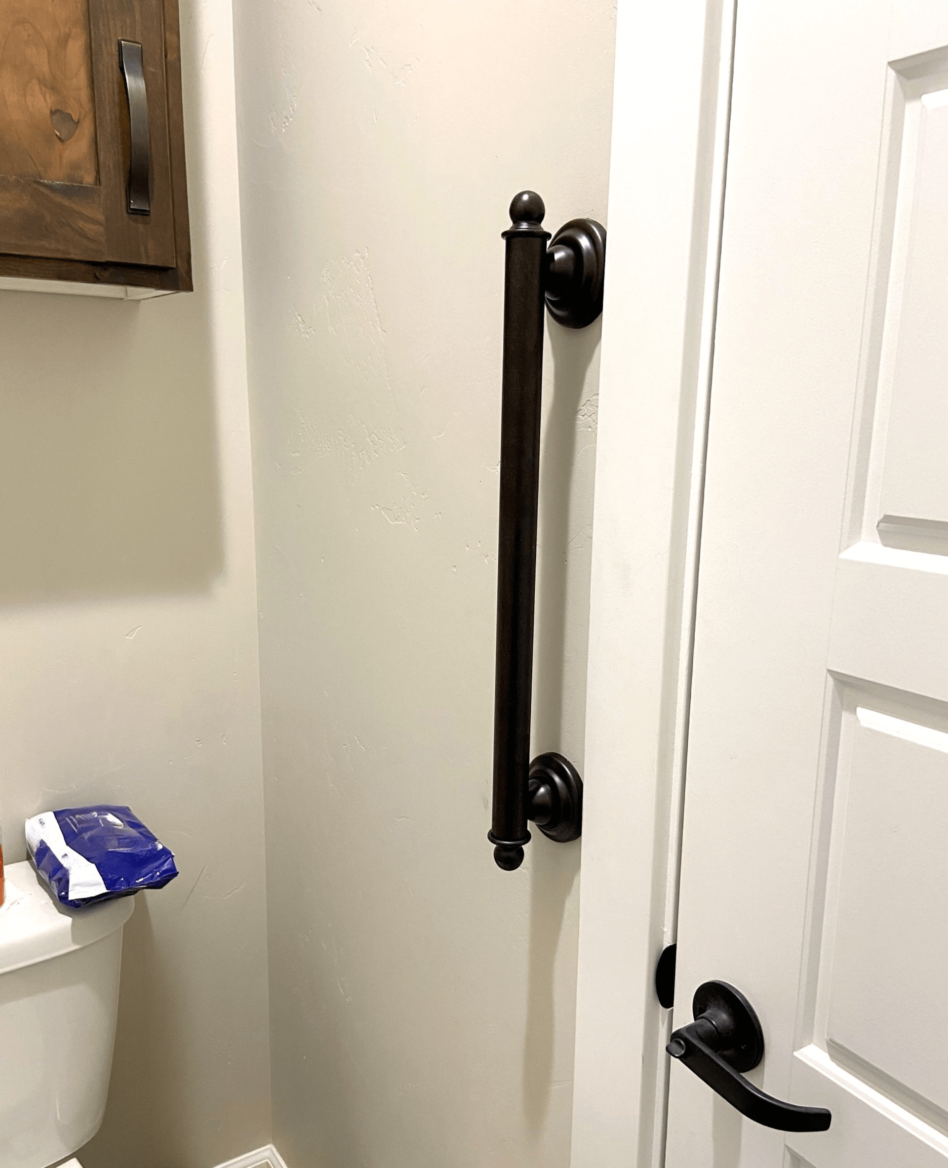A bathroom with a toilet and a door with a handle on it.
