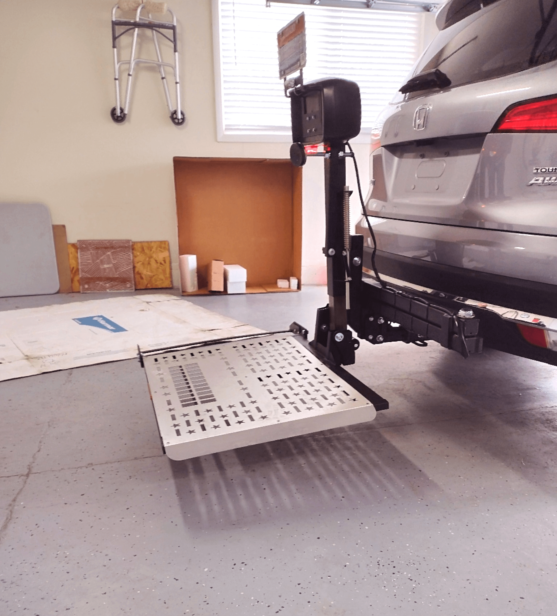A car is parked in a garage with a ramp attached to it.
