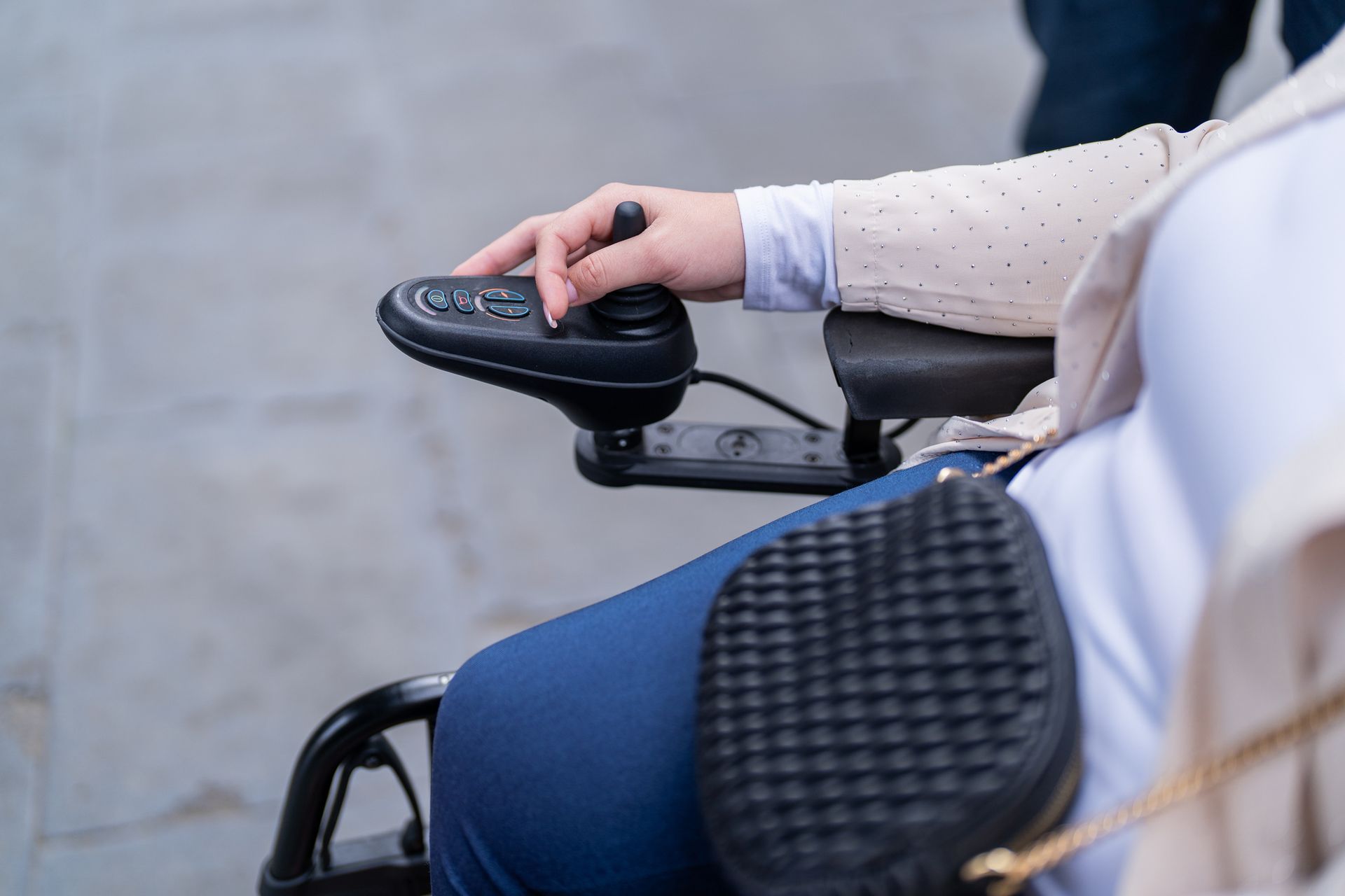 Hand on joystick controlling electric wheelchair. Hand on joystick controlling electric wheelchair.