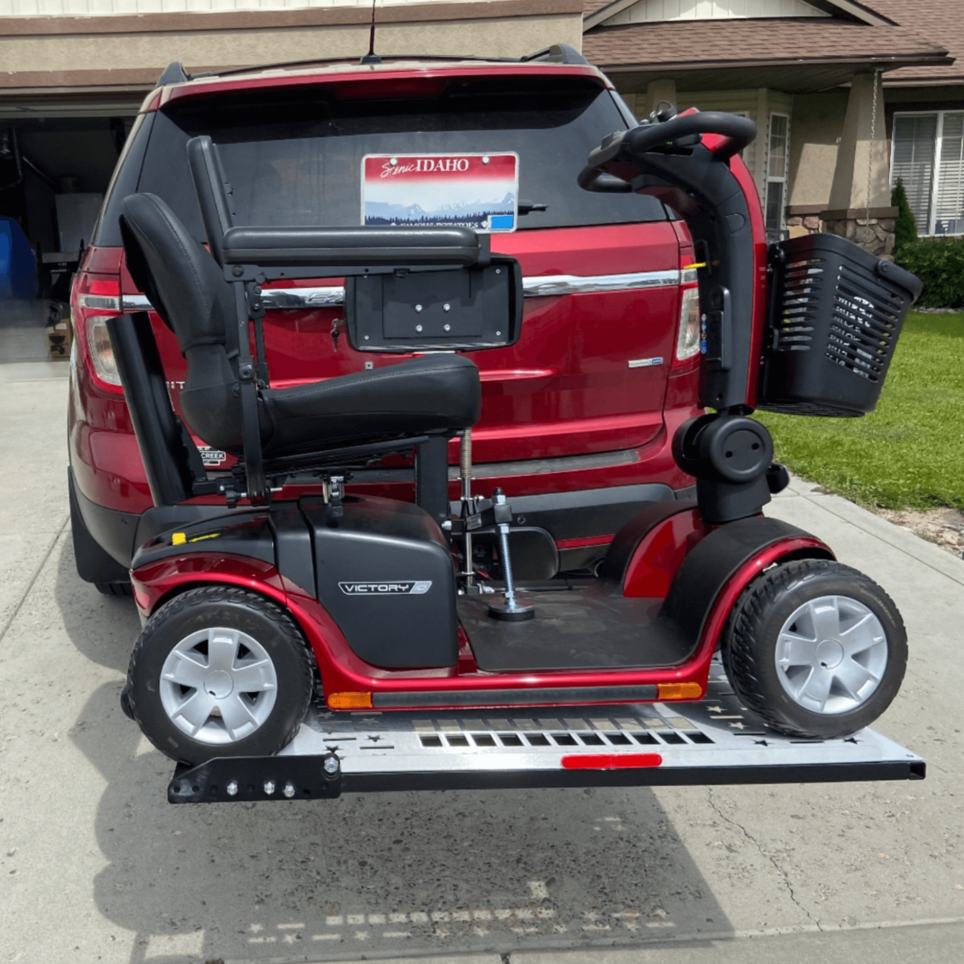 A mobility scooter is attached to the back of a red van
