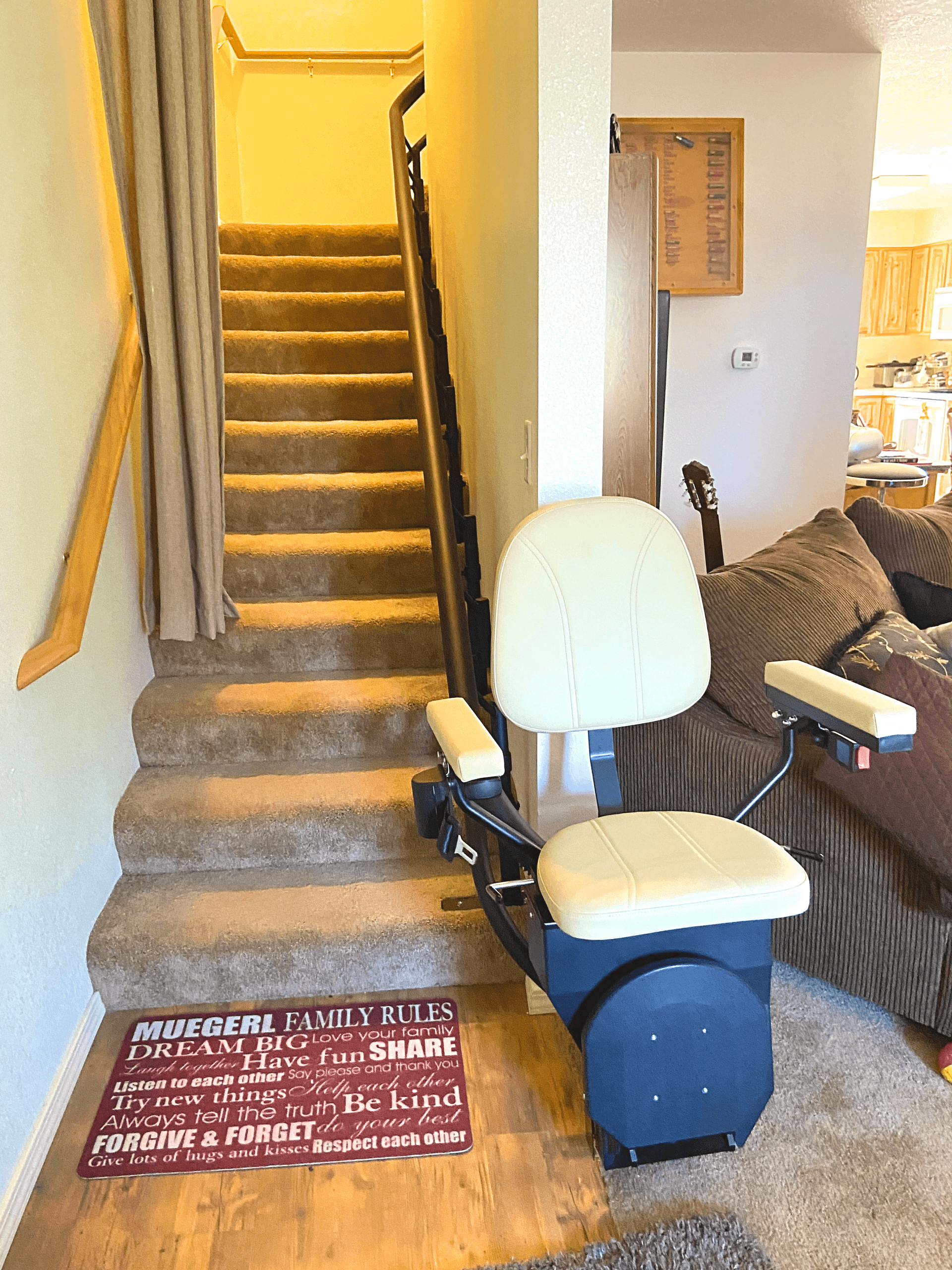 A stair lift is sitting next to a set of stairs in a living room.