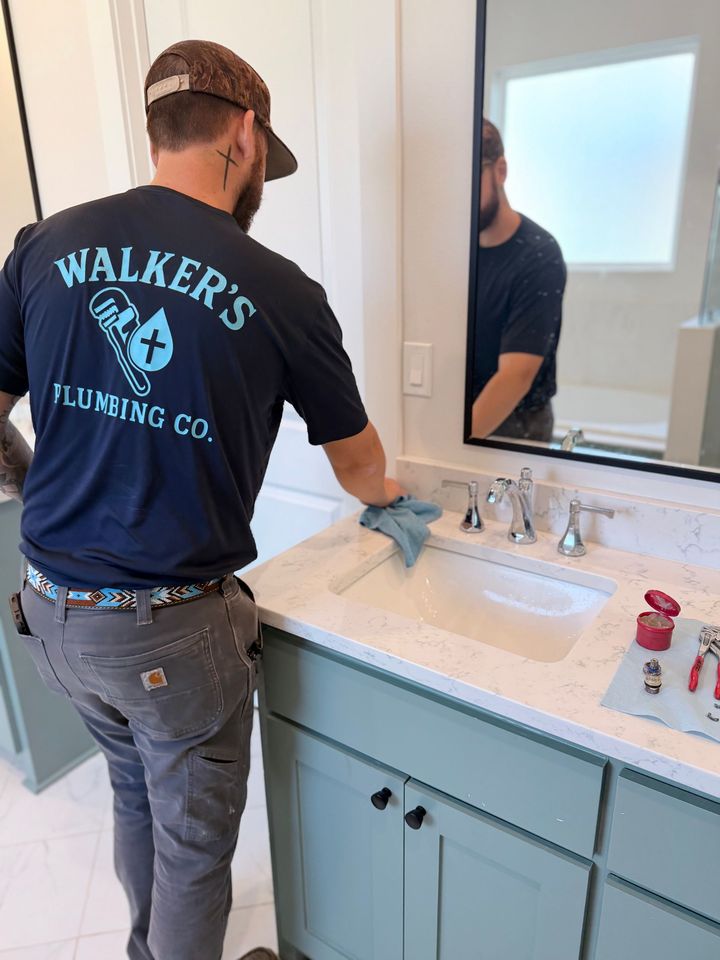 Person using locking pliers to repair plumbing under a sink