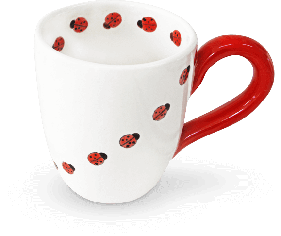 Eine weiße Tasse mit Marienkäfern darauf und einem roten Henkel