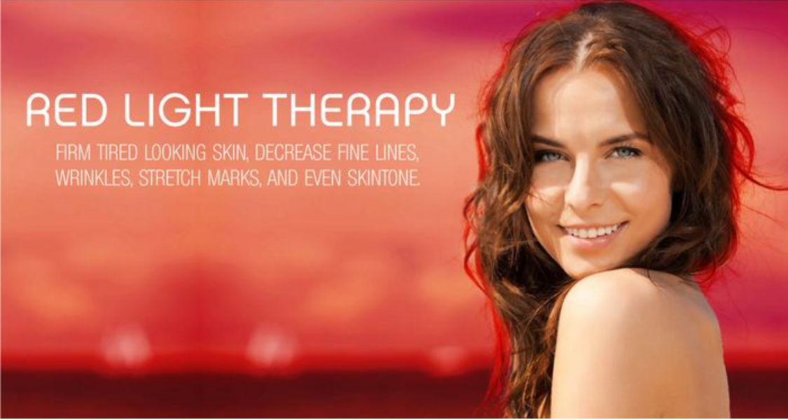 A woman is smiling in front of a red light therapy ad.