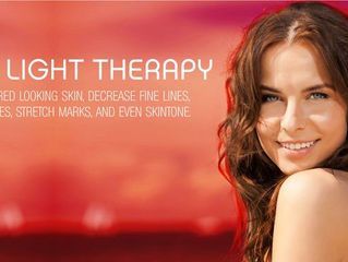 A woman is smiling in front of a red background with the words light therapy on it.