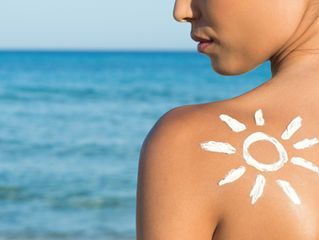 Sunscreen painted as a sun on woman's back. Fit n Tan St. Louis gives tips on using tanning lotion for tanning beds near you.