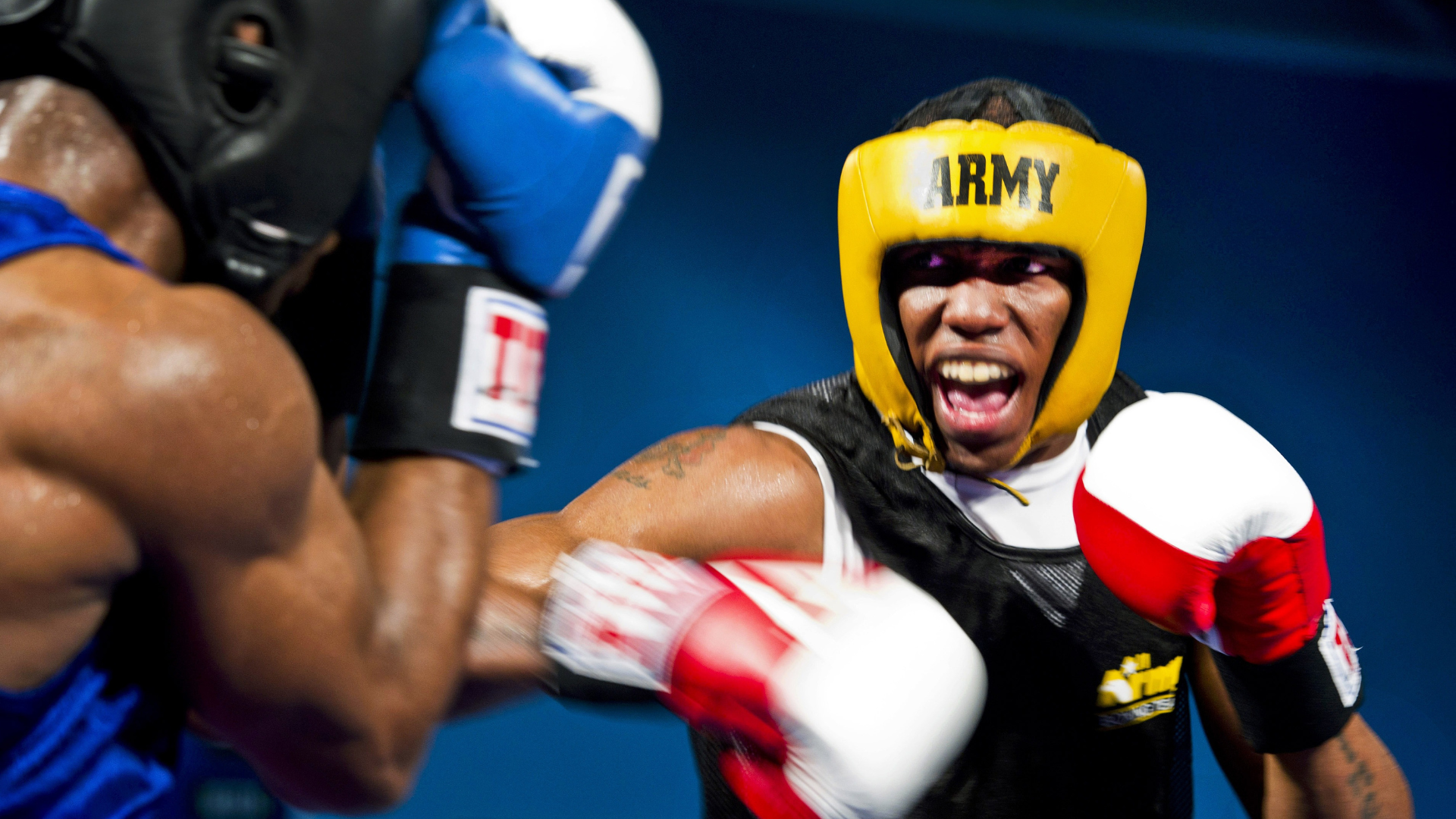 A person is holding a pair of boxing gloves in their hand.