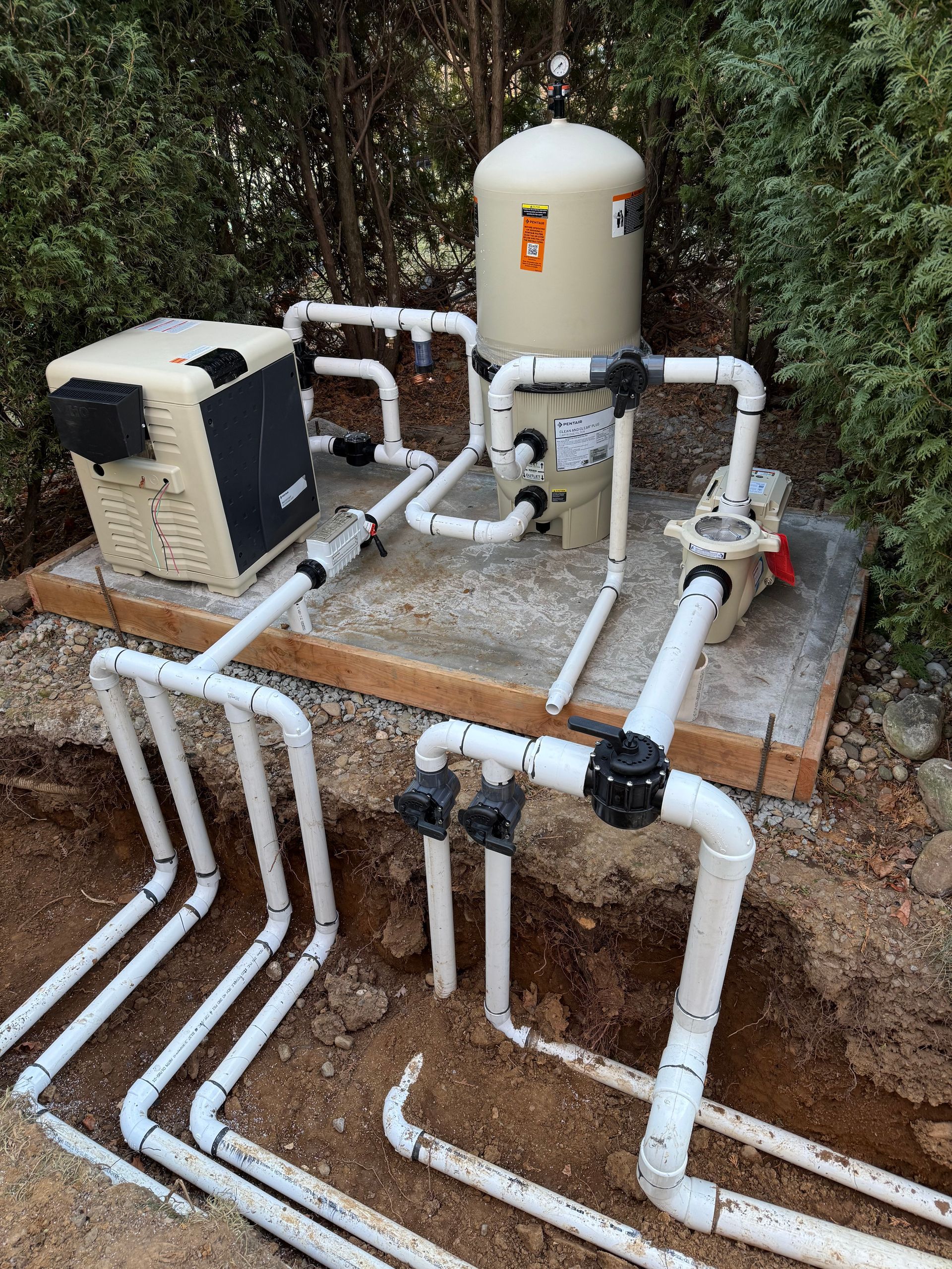 A swimming pool system is being installed in the dirt.