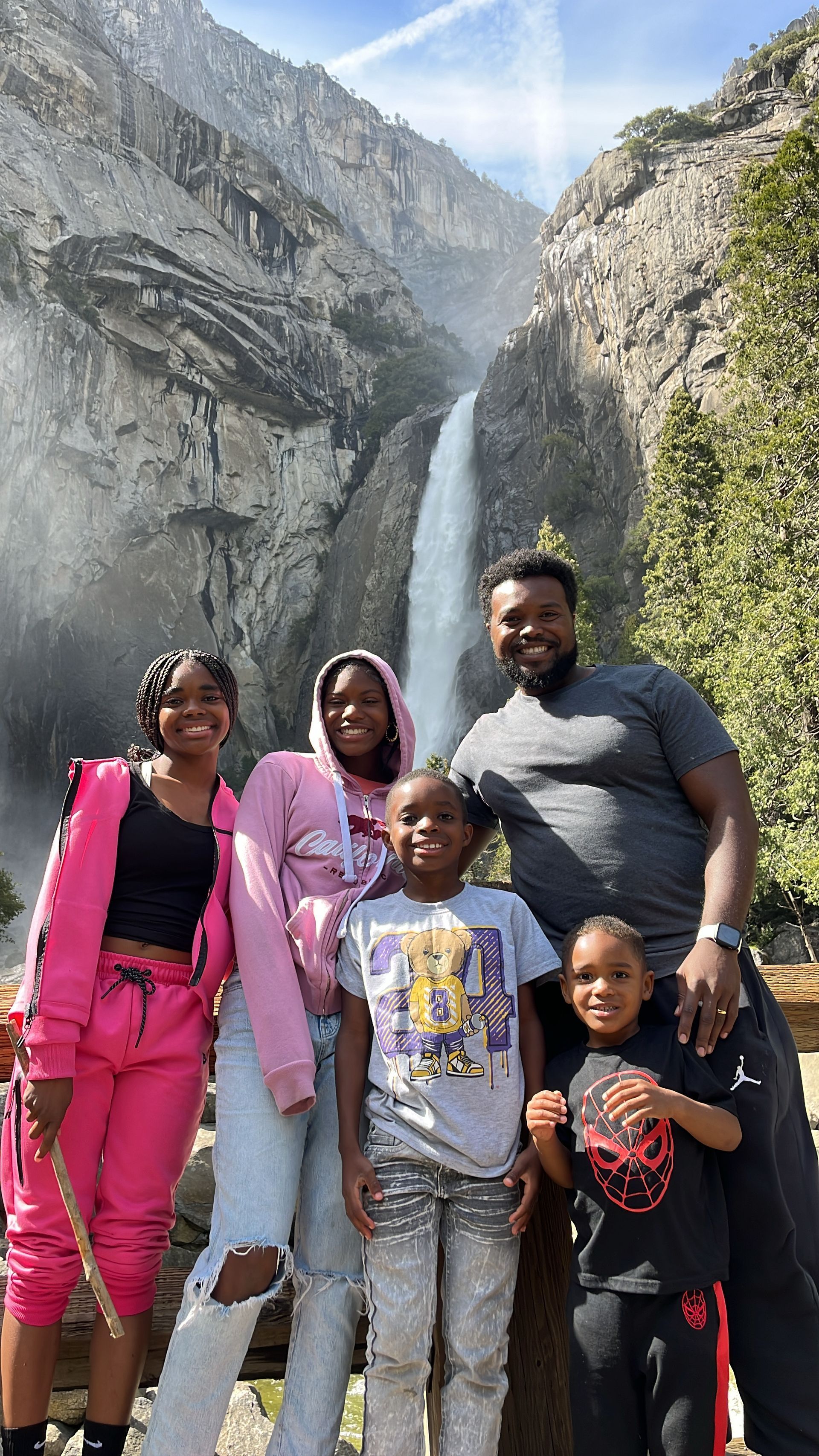 Barron family poses for a photo in front of lower Yosemite falls.