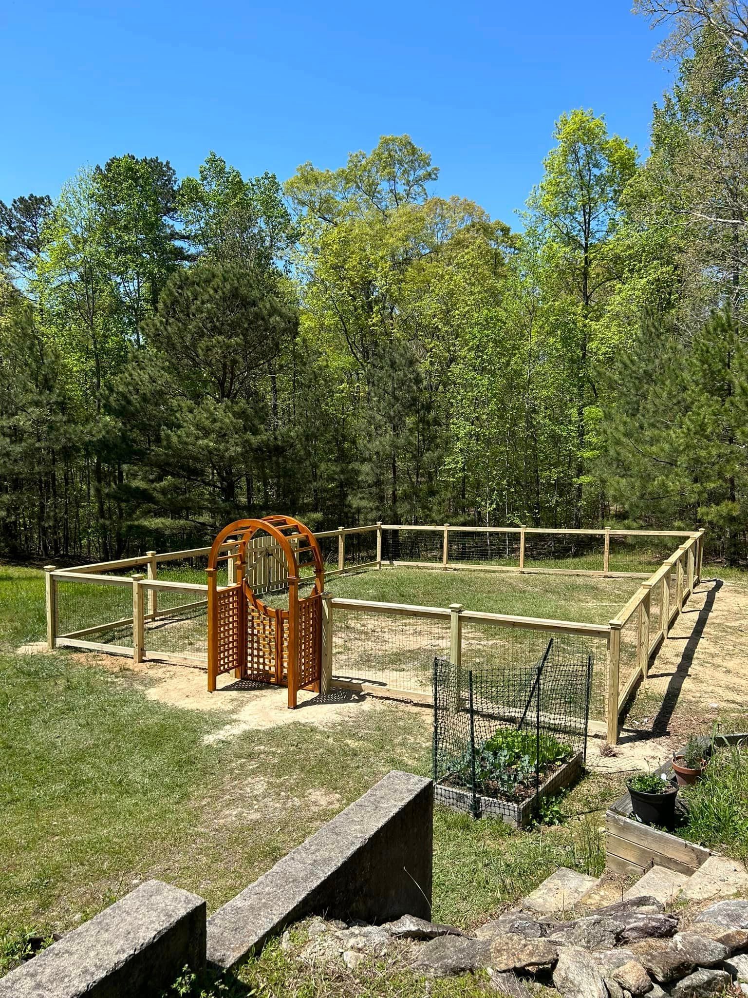 There is a playground in the middle of the yard surrounded by trees.