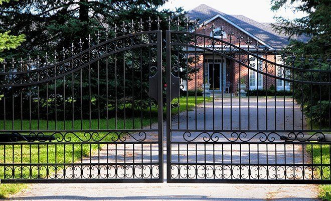 A wrought iron gate leading to a brick house