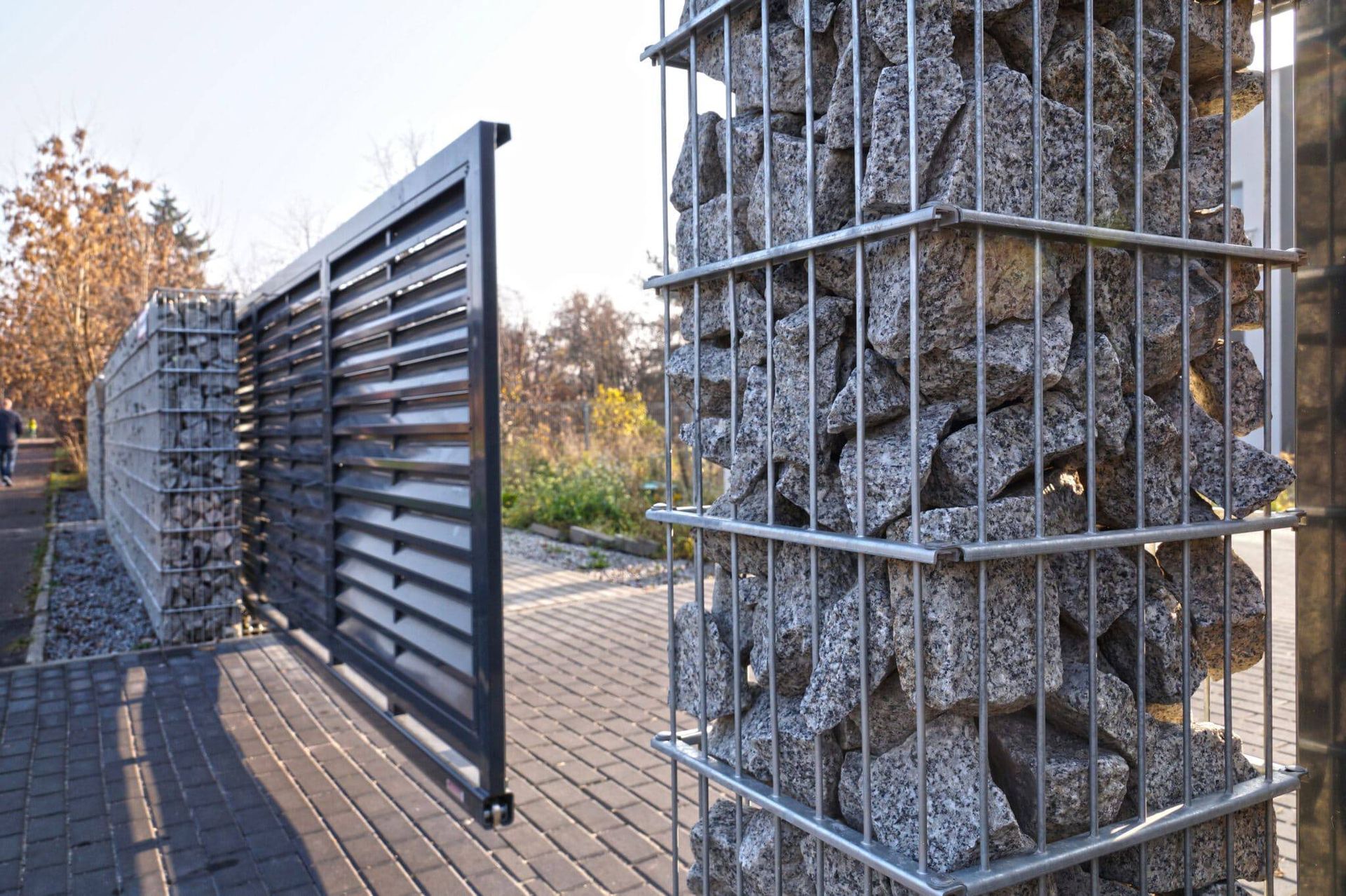 A fence with a gate and a fence made of rocks.