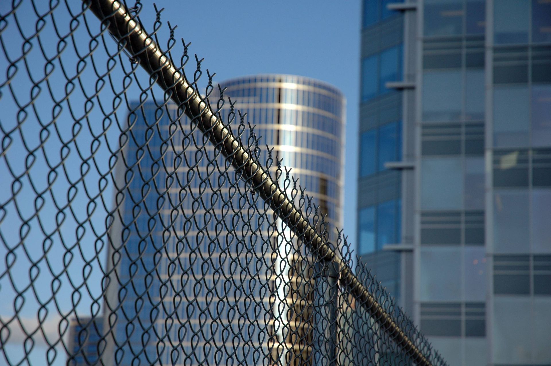 A chain link fence with a building in the background
