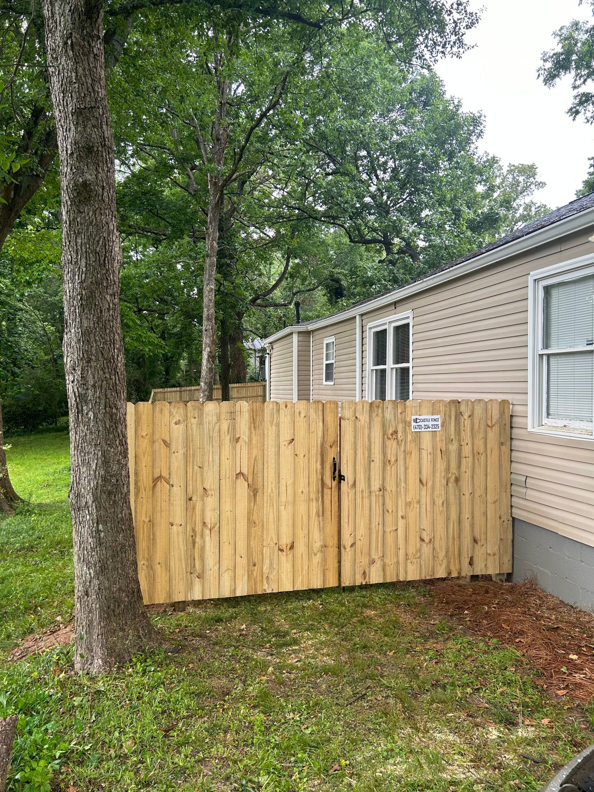 A wooden fence is in front of a mobile home.