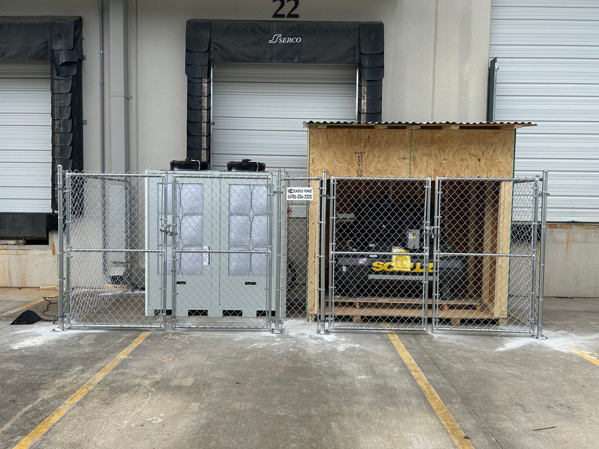 A chain link fence surrounds a building with the number 22 on it