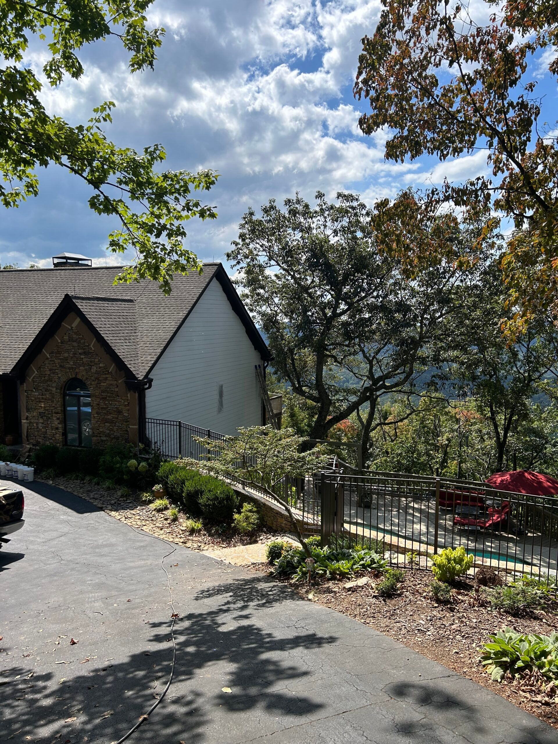 A truck is parked in front of a house on a hill.