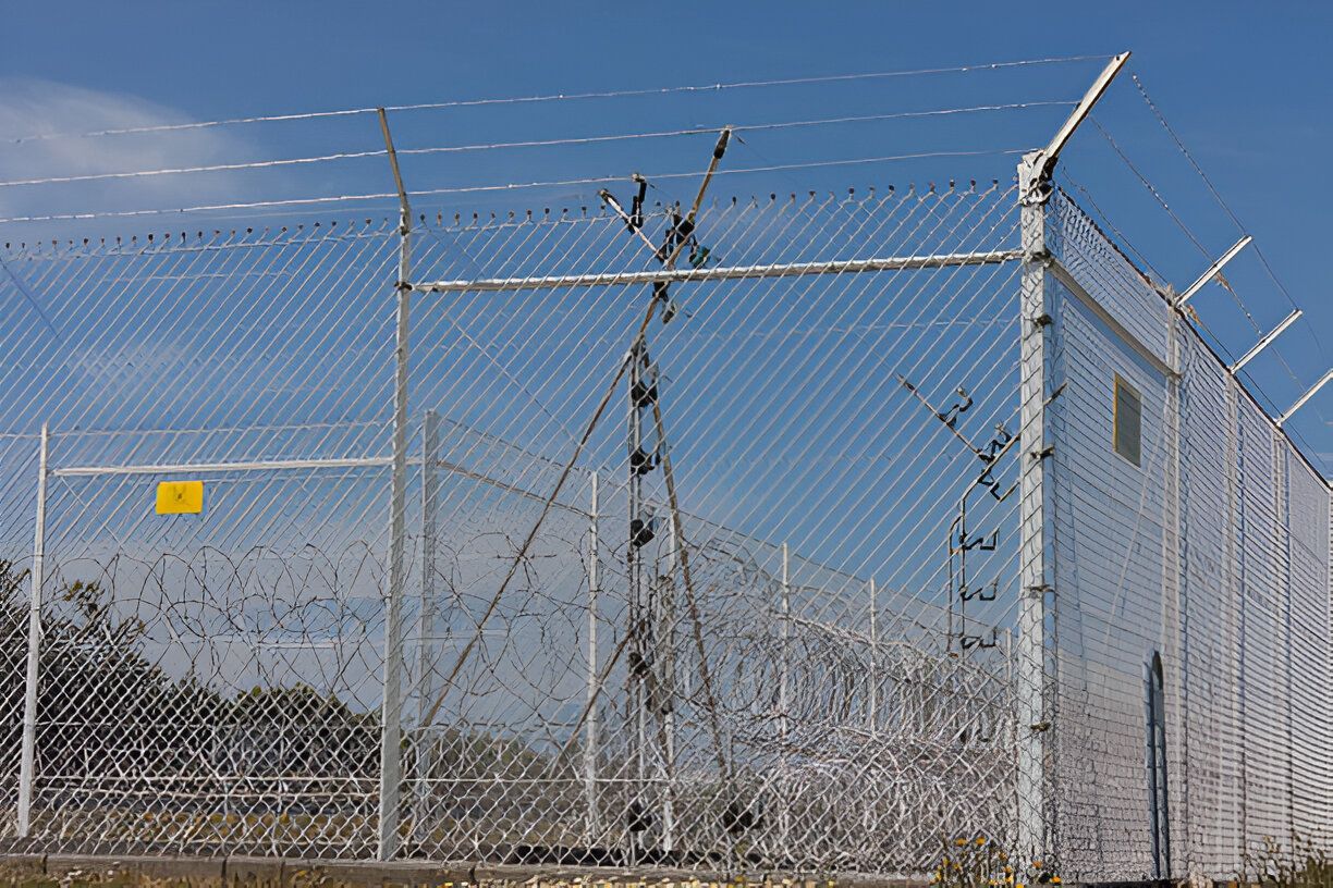 A chain link fence with barbed wire on top of it
