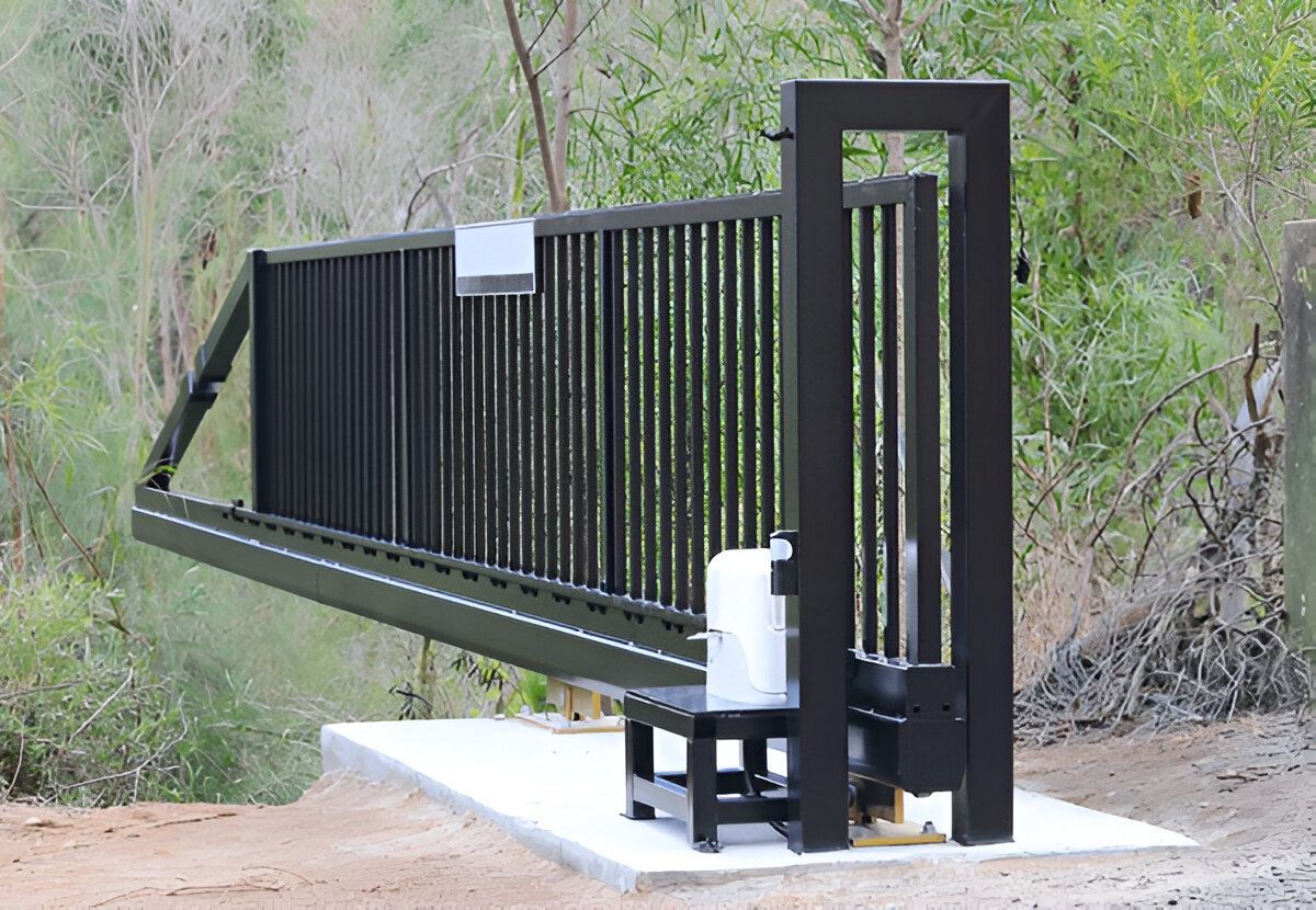 A black sliding gate is sitting on top of a concrete platform.