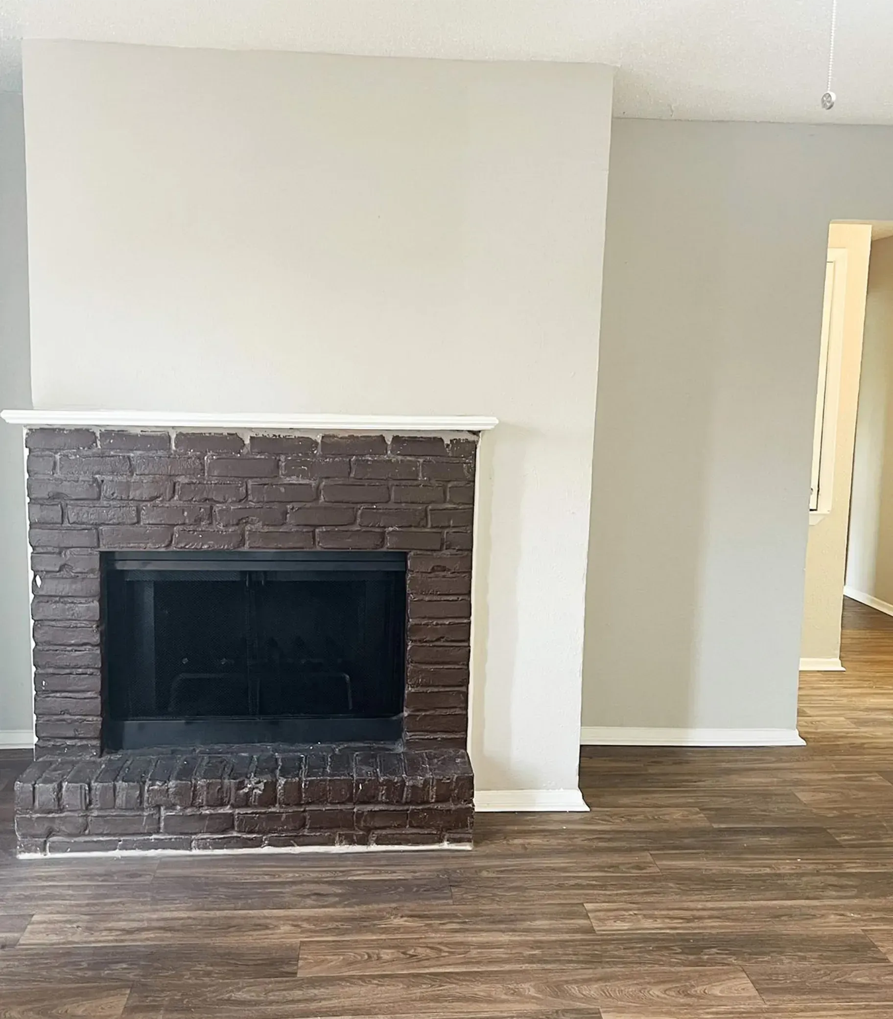 There is a brick fireplace in the middle of the room.