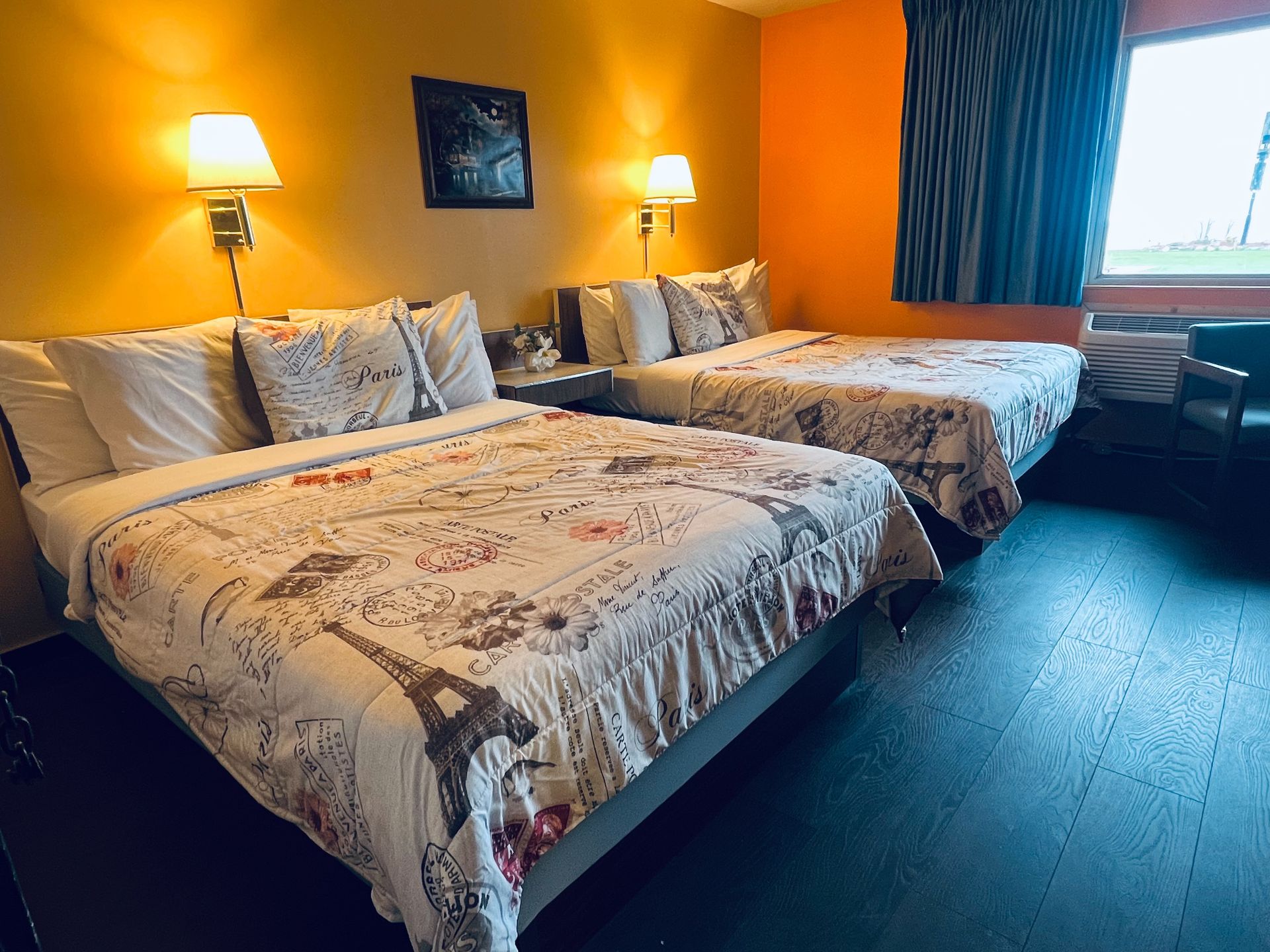 A hotel room with two beds and a chair.