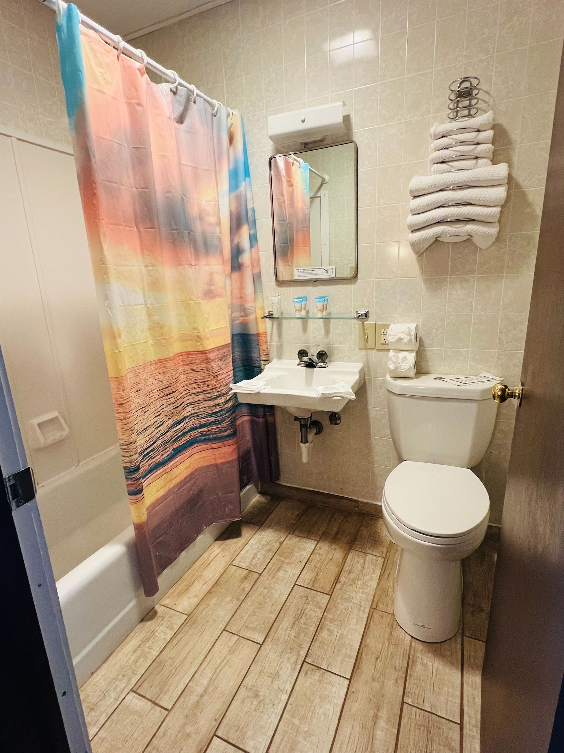 A bathroom with a toilet , sink , and shower curtain.