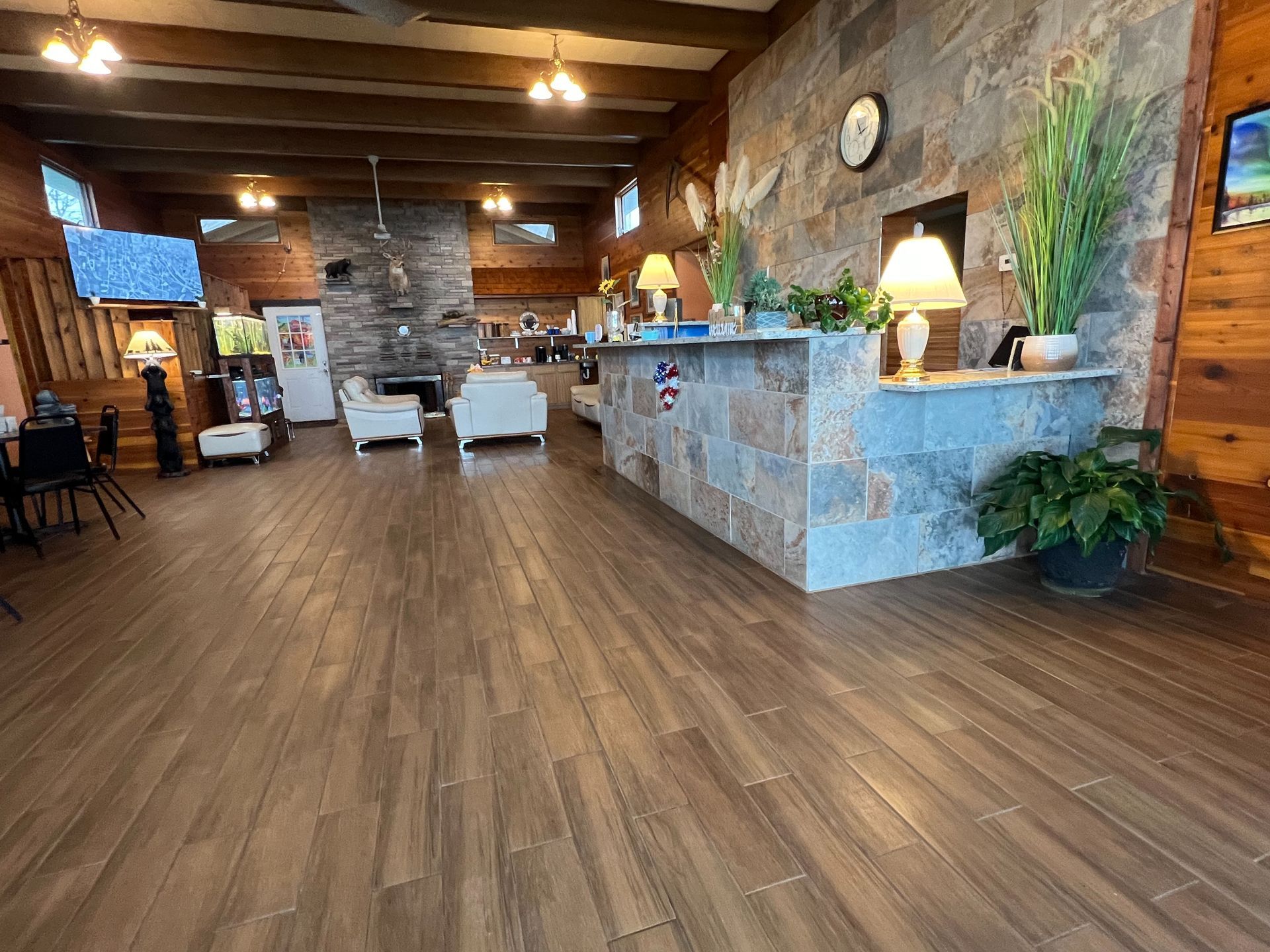 A large room with a wooden floor and a stone wall.