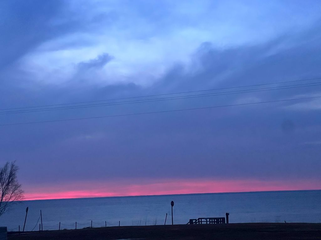 A sunset over a body of water with a dock in the foreground.